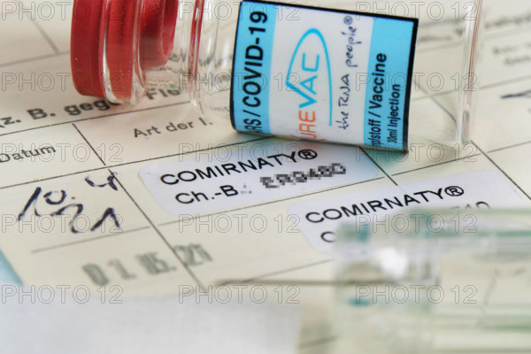 2ter Covid-19 Eintrag in einem Impfpass bei medizienischem Personal mit Serumflasche. Impfung-Covid-19 *** 2nd Covid 19