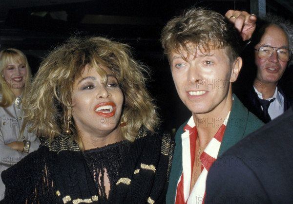 TINA TURNER & DAVID BOWIE London, England, Circa 1985 headshot portrait red lips lipstick red white stripe shirt green j