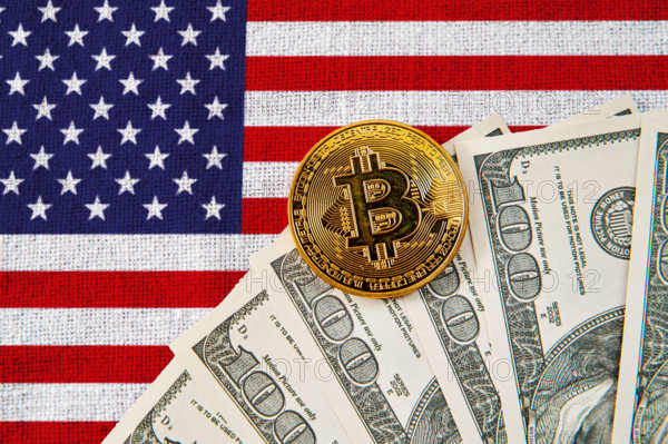 Germany - November 6, 2024: Bitcoin coin and US dollar bills in front of the American flag. Symbolic image for the role