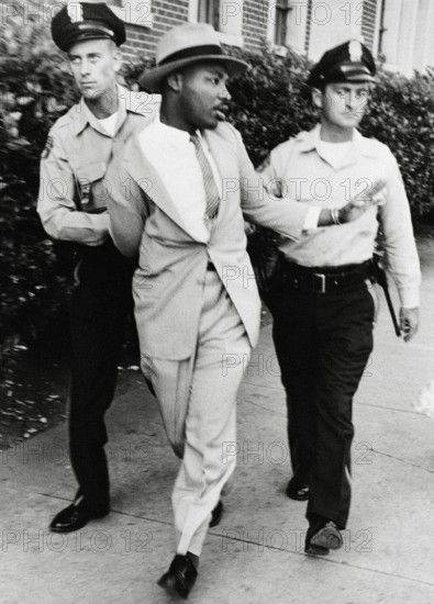 Police officers O.M. Strickland and J.V. Johnson arresting the Reverend Martin Luther King Jr. for loitering near a cou