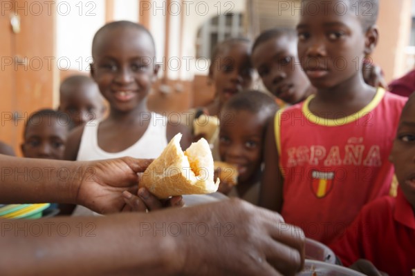 Frau versorgt Kinder mit einer Mahlzeit, Cotonou, Benin, 03.01.2016. . Cotonou Benin PUBLICATIONxINxGERxSUIxAUTxONLY Co