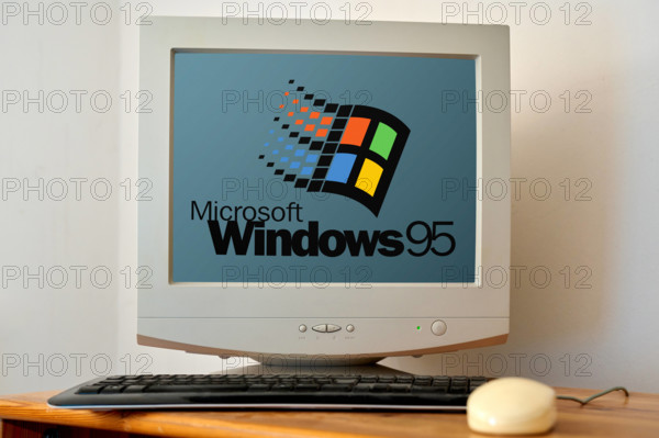 April 21, 2024: Old computer on a desk with a screen showing the Microsoft Windows 95 logo. PHOTOMONTAGE *** Alter Compu