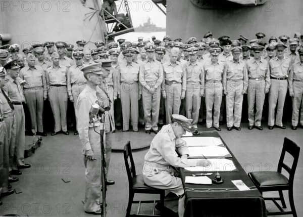 JAPANESE SURRENDER General Douglas MacArthur signs as Supreme Allied Commander during formal surrender ceremonies on the