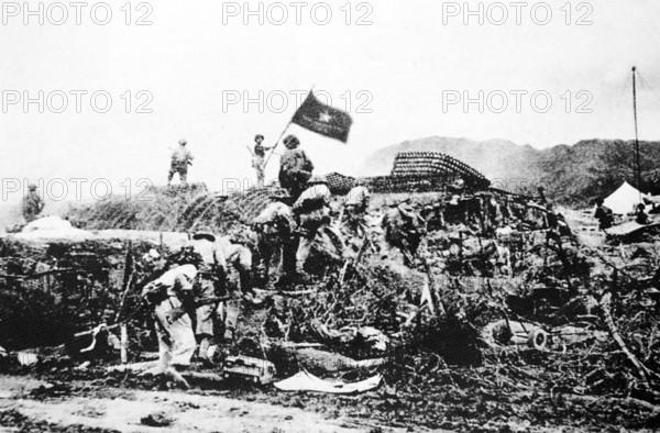 RECORD DATE NOT STATED Vietnam: Victorious Viet Minh troops wave a Vietnamese flag over captured French command post at