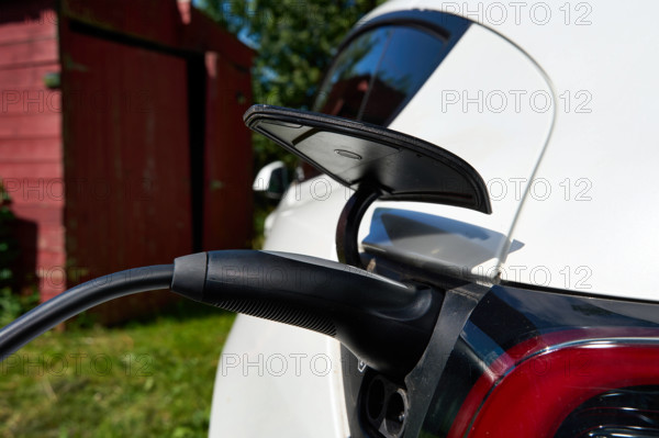 Bavaria, Germany - June 24, 2025: Detailed view of a Tesla Model Y during the charging process. A charging cable is conn