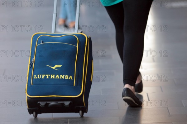 Frau und Rollkoffer mit Lufthansa Logo unterwegs im Hauptbahnhof Frankfurt, Hessen, Deutschland