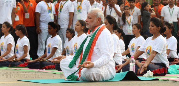 NEW DELHI, INDIA - JUNE 21: Prime Minister Narendra Modi performs yoga along with others at Rajpath during mass yoga se