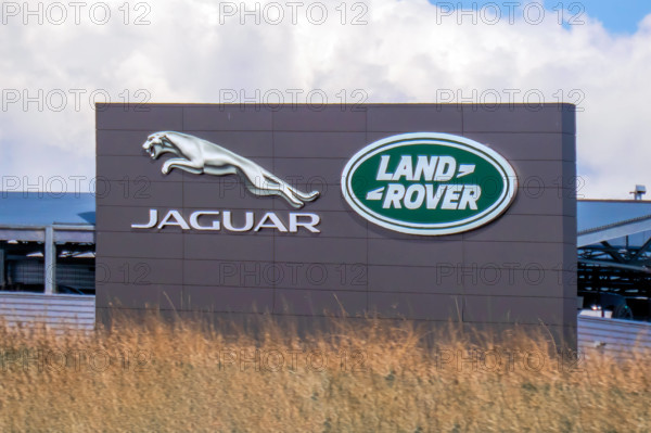 Calgary, Alberta, Kanada. 5. Juni 2025. Die kultigen Logos von Jaguar und Land Rover prangen auf einem modernen Gebäude und stehen für automobile Spitzenleistungen und britisches Erbe.