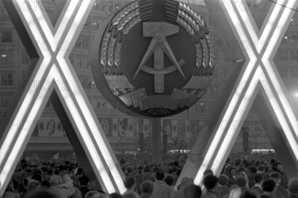 Bildnummer: 52242365  Datum: 07.10.1969  Copyright: imago/Stana
Emblem der DDR während der Feierlichkeiten anlässlich des 20. Jahrestages der DDR in Berlin Ost , Objekte , Personen; 1969, sw, DDR, Ostberlin, Berlin Ost, Nationalfeiertag, Tag der Republik, Jahrestag, XX, Sozialismus, Propaganda, Schriftzug, Menschenmasse; , quer, Kbneg, Einzelbild, Wappen, Logos, Deutsche Demokratische Republik,  , Gesellschaft