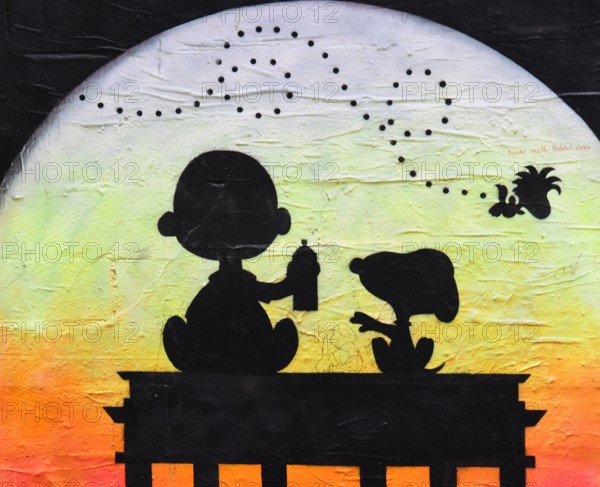 Charlie Brown und Snoopy sitzen auf dem Brandenburger Tor und sinnieren im Abendrot über die Weltenlaeufe. Wandmalerei