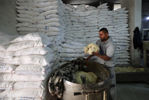 Workers package bread for distribution at the World Food Programme (WFP) bakery after a limited amount of flour entered the Gaza Strip
