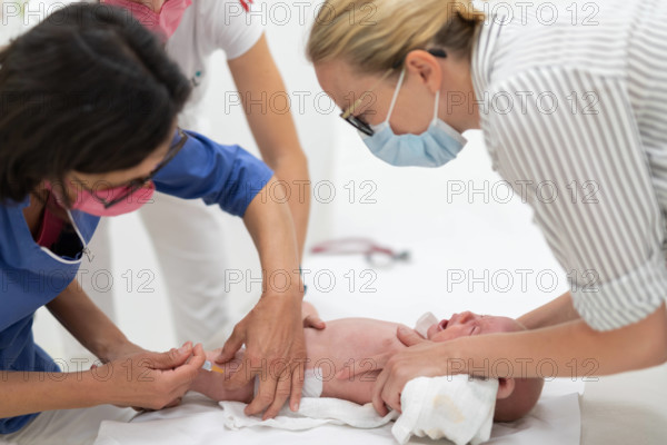 Baby beeing vaccinated by pediatrician in presence of his mother. Preventive vaccination against Diphtheria, whooping co