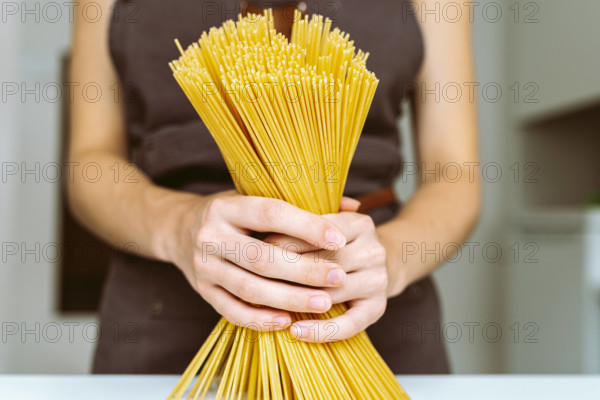 Koch mit Spaghetti in der Hand