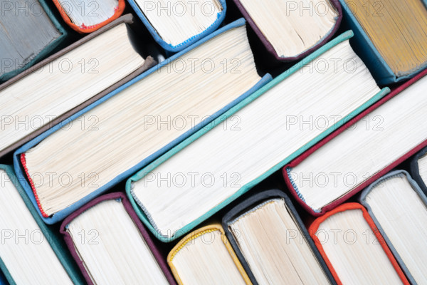 Stack of hardcover books on bookshelf. Close-up view of vintage hardback books as background Stack of hardcover books on