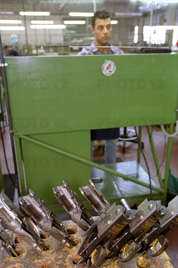 ITALIE. L'USINE D'ARMEMENT BERETTA, L'UNE DES PLUS CELEBRES DANS LA FABRICATION D'ARMES DE CHASSE OU DE GUERRE. LE TRAVAIL DES OUVRIERS QUI ASSEMBLENT LES CANONS.