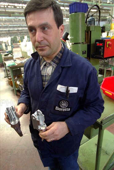 ITALIE. L'USINE D'ARMEMENT BERETTA A VAL TROMPIA, L'UNE DES PLUS CELEBRES DANS LA FABRICATION D'ARMES DE CHASSE OU DE GUERRE. LE TRAVAIL DES OUVRIERS QUI ASSEMBLENT LES CANONS.