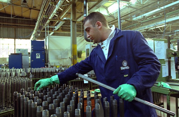 ITALIE. L'USINE D'ARMEMENT BERETTA A VAL TROMPIA, L'UNE DES PLUS CELEBRES DANS LA FABRICATION D'ARMES DE CHASSE OU DE GUERRE. LE TRAVAIL DES OUVRIERS QUI ASSEMBLENT LES CANONS.