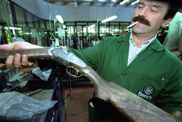 ITALIE. L'USINE D'ARMEMENT BERETTA A VAL TROMPIA, L'UNE DES PLUS CELEBRES DANS LA FABRICATION D'ARMES DE CHASSE OU DE GUERRE. L'OUVRIER RESPONSABLE DU FACONNAGE DES CROSSES.