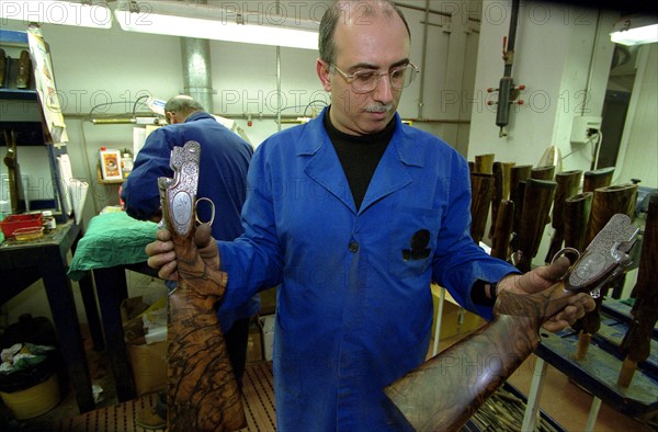 ITALIE. L'USINE D'ARMEMENT BERETTA A VAL TROMPIA, L'UNE DES PLUS CELEBRES DANS LA FABRICATION D'ARMES DE CHASSE OU DE GUERRE. L'ATELIER DE HUILAGE ET DE VERNISSAGE DES CROSSES EN NOYER.