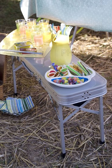 Pique-nique "Tour de France" : bonbons et jus de fruits sur un banc de camping