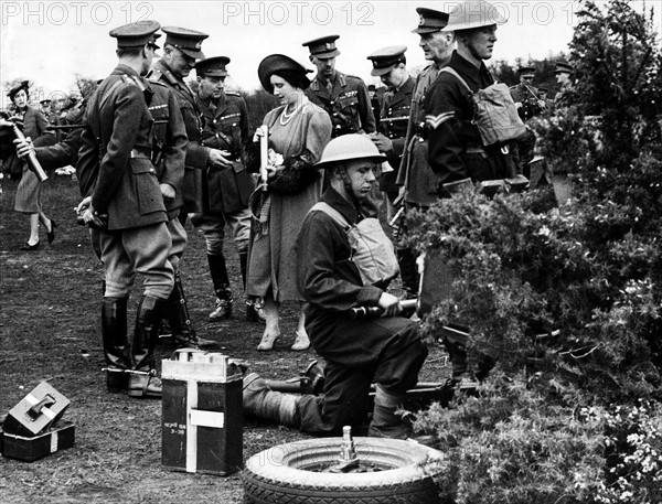 King George VI April 1939 looking at the Queen examining an anti land shell