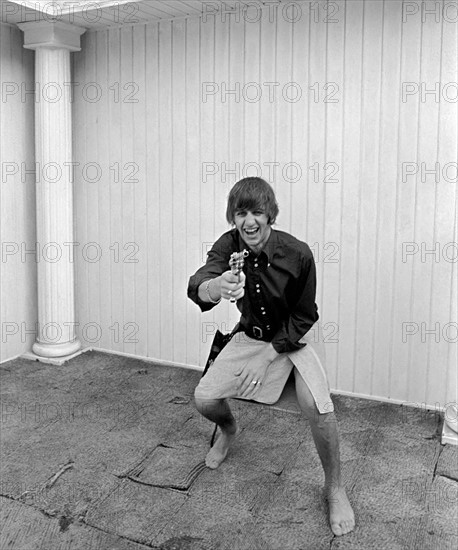 Beatles at pool in a private home in Los Angeles. Ringo Starr playing cowboy at Beatles Bel Air home. 
August 1964 
S07559