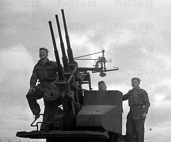 British troops on the anti aircraft gun in a Normandy town in Northern France shortly after the D-Day landings begun the Allied invasion of the continent during World War Two
June 1944