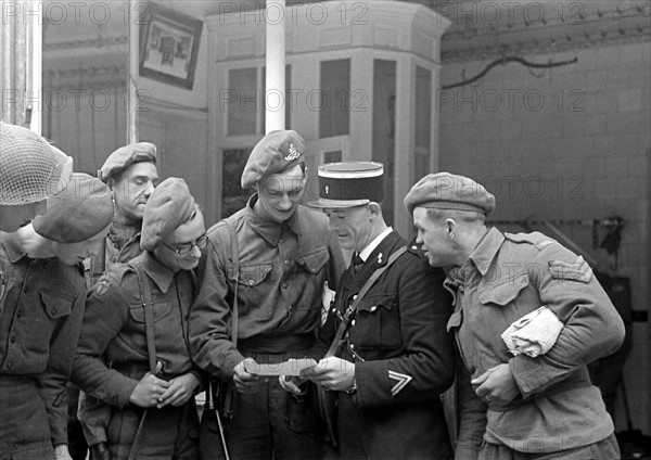 Soldats britanniques parlant avec un gendarme français, en juillet 1944