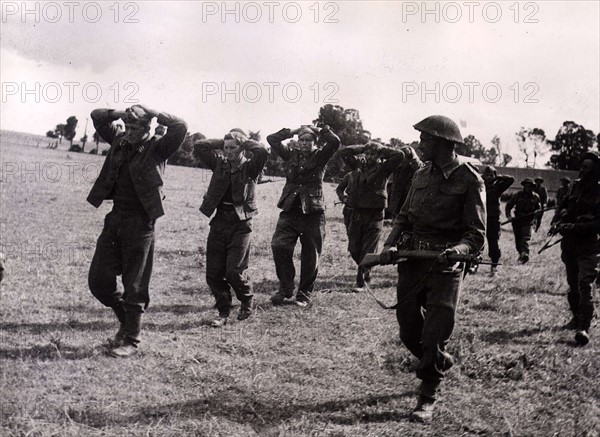 World War II Invasion of France
German prisoners of war captured during the battle for Caen at the begin of July, being led by a soldier - they walk with their hands on their heads under armed guard . Many in this group were serving with the Hitler Youth Division
July1944