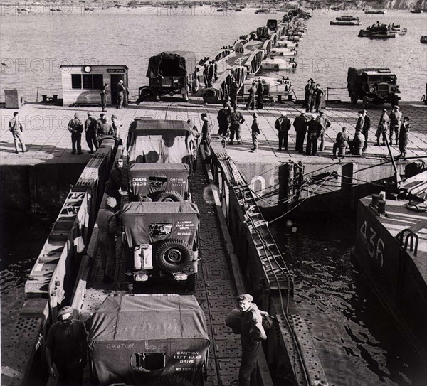 World War II Invasion of France - Operation Overlord
Lorries and jeeps driving off the Mulberry harbour at Gold Beach Arromanches. A Mulberry was a prefabricated harbour . Over 8,000 men worked for eight months to build these floating structures which, when finished together weighed nearly a million tonnes and in addition to the concrete used involved 110,000 tonnes of steel.
June 1944