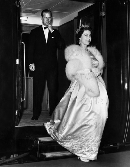Her Majesty Queen Elizabeth II, followed closely behind by her husband Prince Philip, the Duke of Edinburgh, leaves the Royal train at Lime Street Station, Liverpool for an evening engagement at the start of their Lancashire tour.
May 1961.