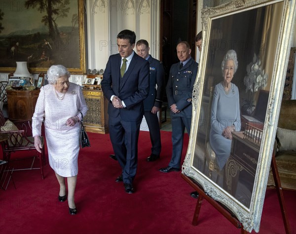 La reine Elisabeth II observant un nouveau portrait d'elle au château de Windsor