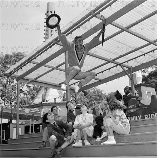 Sammy Davis Jnr rehearsing with some children at Battersea Festival Gardens for his new film 'Sammy Davis meets the British'
26th May 1960.
M4112
