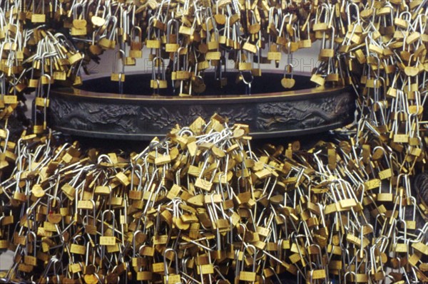Innumerous locks adhered to a copper incense burner in Taishan mountain, China