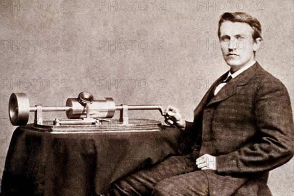 Thomas Edison posant à côté de l'une de ses inventions : le phonographe