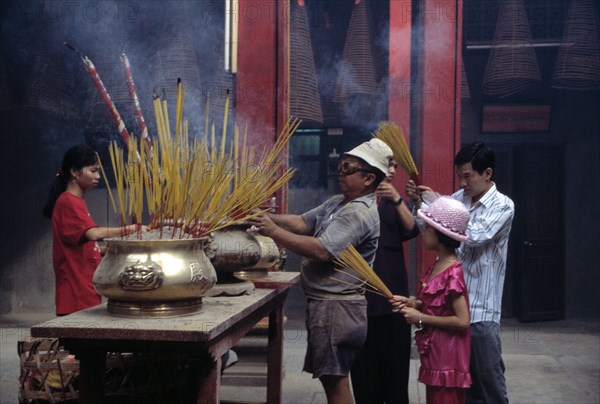 Des fidèles font brûler de l'encens dans un temple taoïste à Saïgon, au Vietnam