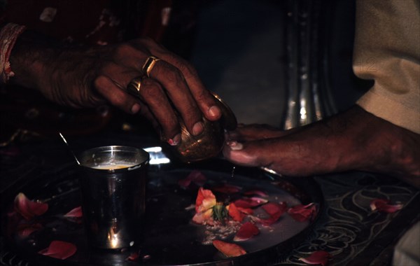 The bride`s mother blessing the bridegroom`s feet at a Hindu wedding ceremony.