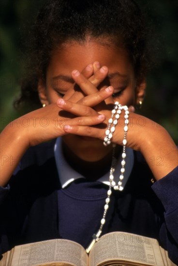 Rosary beads, a woman saying the rosary