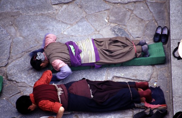 Pèlerins tibétains se prosternant devant le temple de Jokhang, temple principal de Lhassa, au Tibet