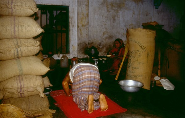 Shop merchant performing the evening prayer