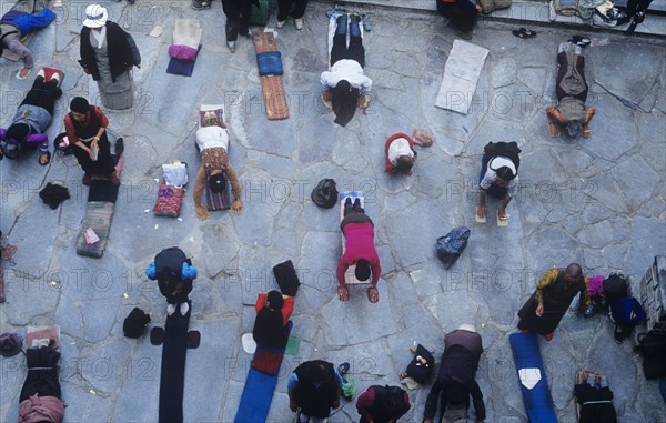 Buddhist pilgrims prostrate outside Johkang Temple in Lhasa Tibet