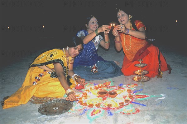 HIndu women designing a rangoil for Divali Festival of Lights India