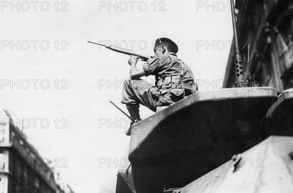 Un militaire français en position de combat dans une rue de Paris, lors de la Libération (août 1944)