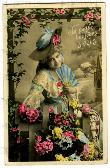 Carte postale représentant une femme posant parmi des fleurs