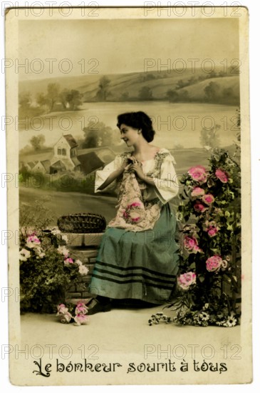 Postcard with a woman among flowers