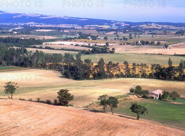 View from the environs of Les Cassés towards the South, over the meanders of the stream lined with trees (in the center)