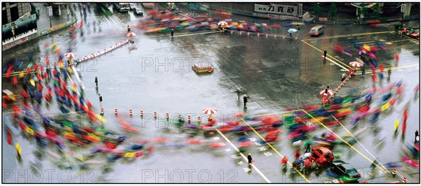 Cyclistes chinois sous la pluie