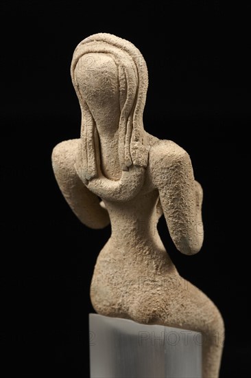 Statuette figuring a seated naked stylized female and a child (vue arrière)