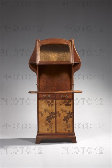 Louis Majorelle (1859-1926)
Meuble de rangement à hauteur d’appui de forme mouvementé, la partie haute vitrée ouvre à un abattant dégageant un intérieur plaqué de ronce de frêne et supporté, la partie basse à plateau débordant ouvre à deux portes ornées de clématites, prises à motif floral stylisé
En palissandre massif, façade par deux fins montants fuselés et marqueterie de bois précieux (156x82x34cm)
Collection particulière
