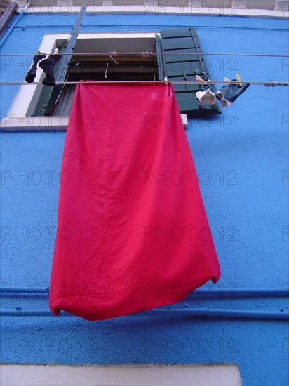 Venise Burano maison de pêcheur, façade de couleur et linge étendu, rouge et bleu